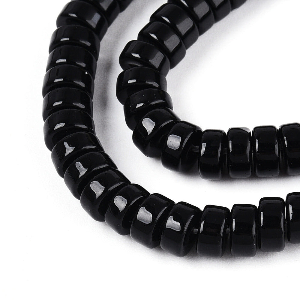 Curved strand of black opaque glass flat round beads, glossy and smooth