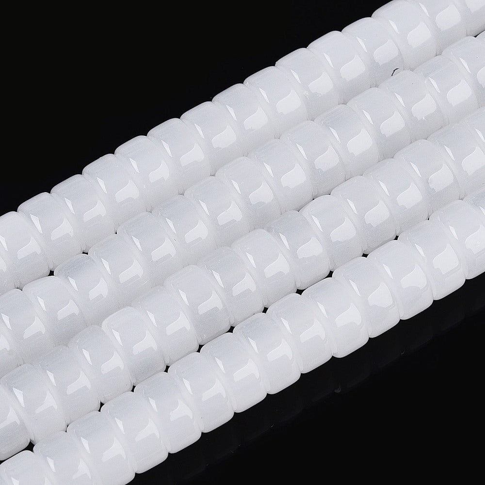 White flat round glass beads strand, close-up with faceted bead texture