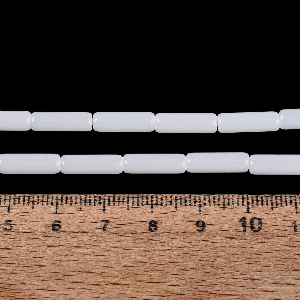 White cylindrical bugle beads on a strand, evenly spaced