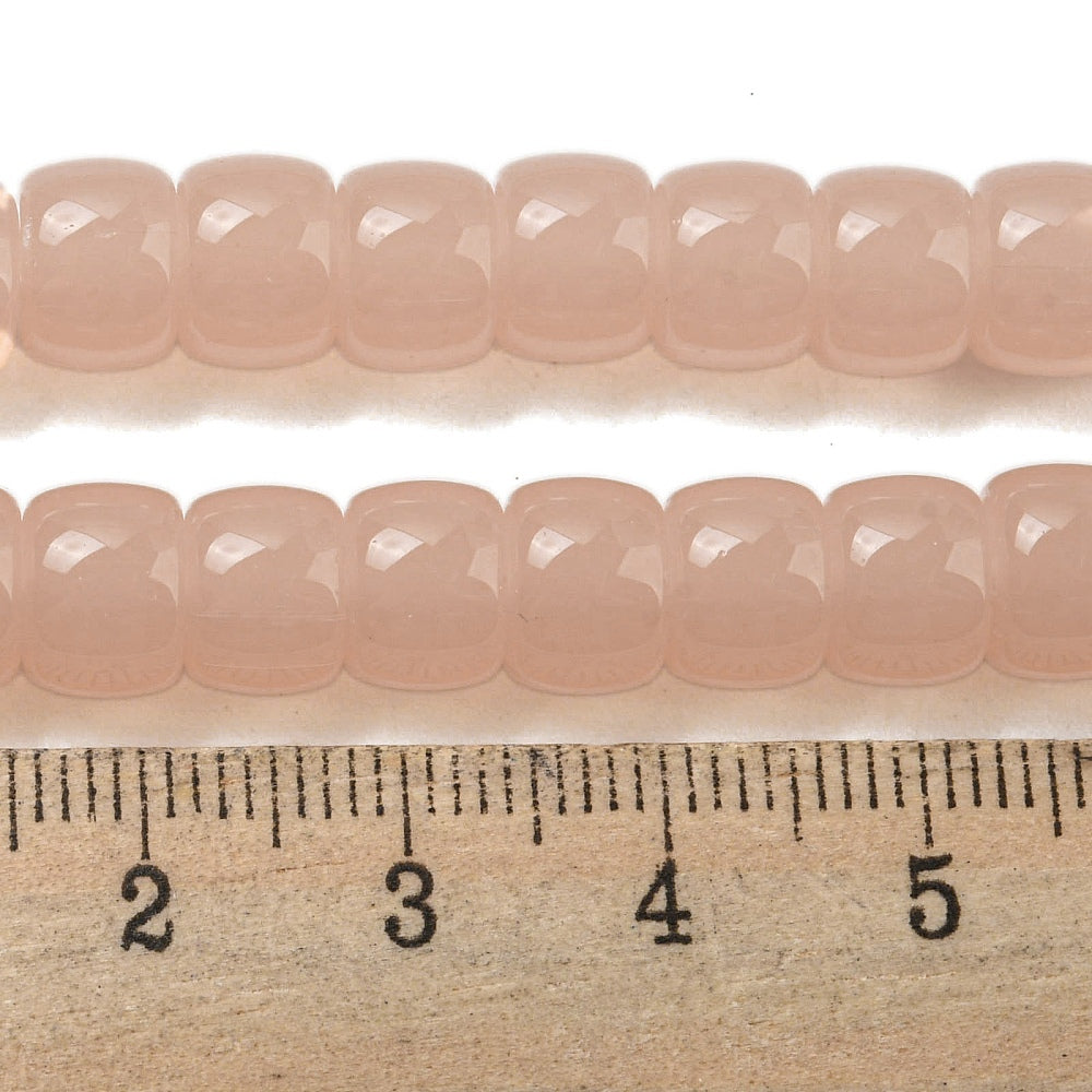Salmon pink barrel beads strand with ruler for scale; faceted barrel beads