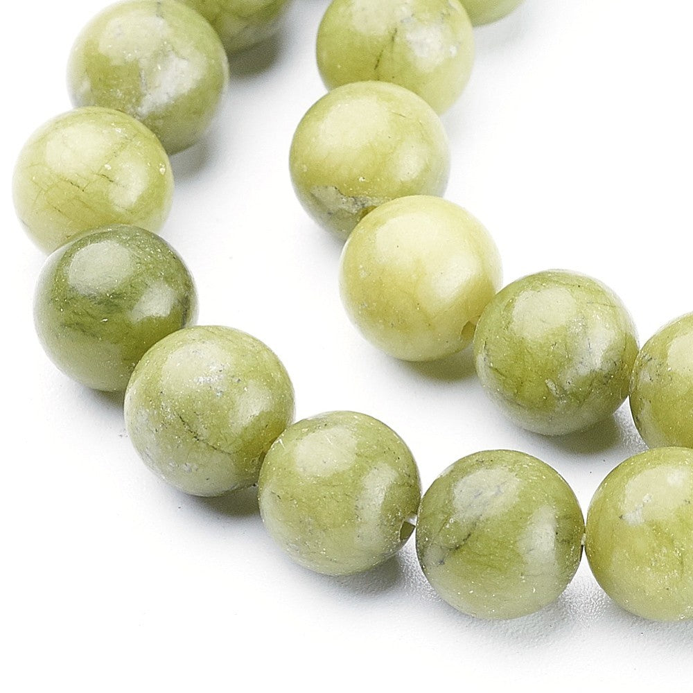 Close-up of round jade beads in pale green, 8mm, smooth surface with natural veining