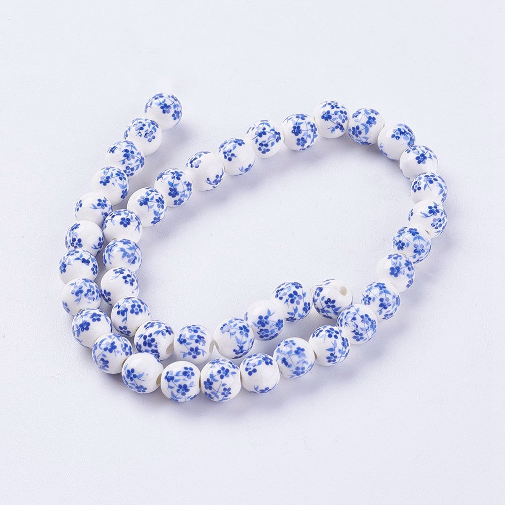 Porcelain round beads bracelet-style strand, white with blue flower motifs