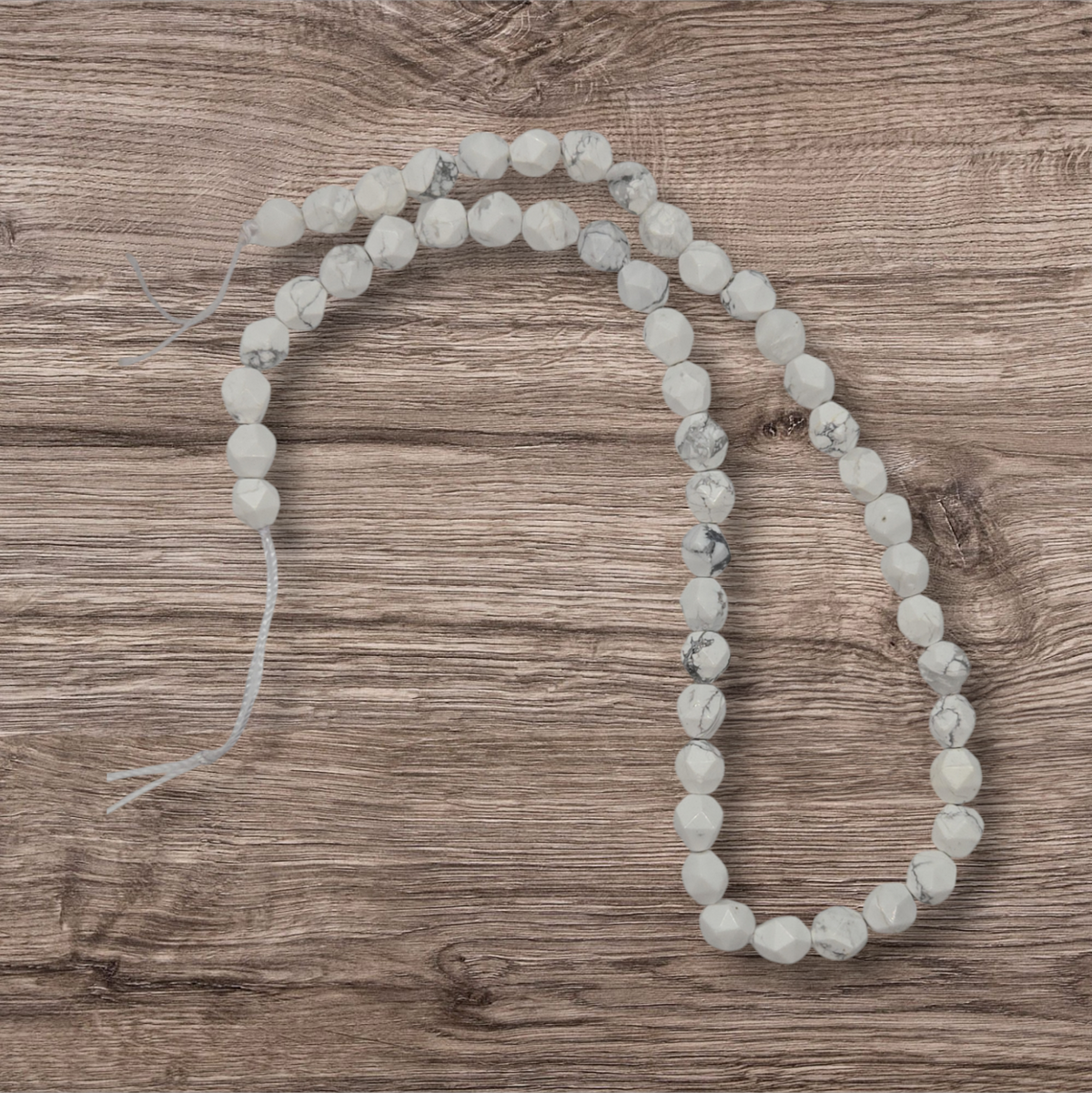 Howlite gemstone bead strand, 8mm faceted round beads, light white-gray.