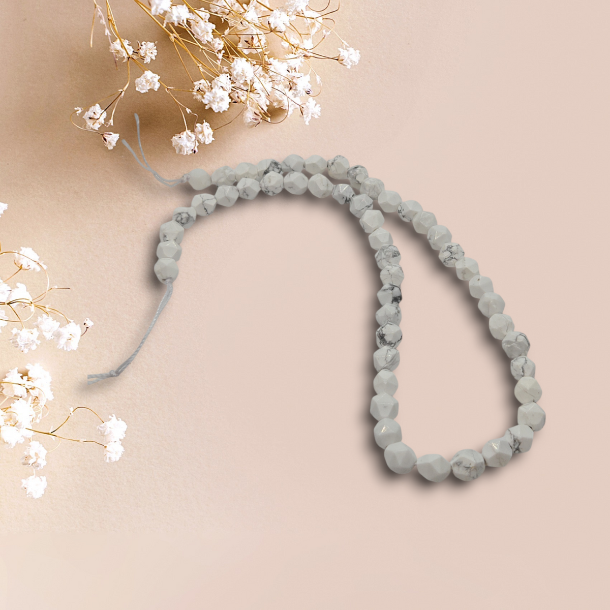 Howlite bead strand with faceted round beads, cool gray tone, flexible loop.