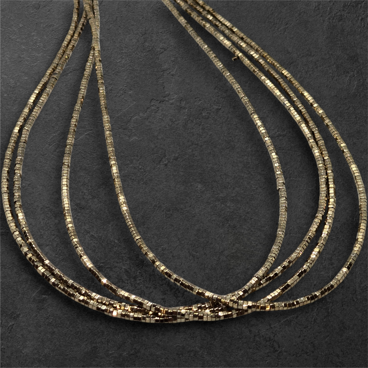 Gold-tone hexagon bead strands (2mm) with metallic black accents