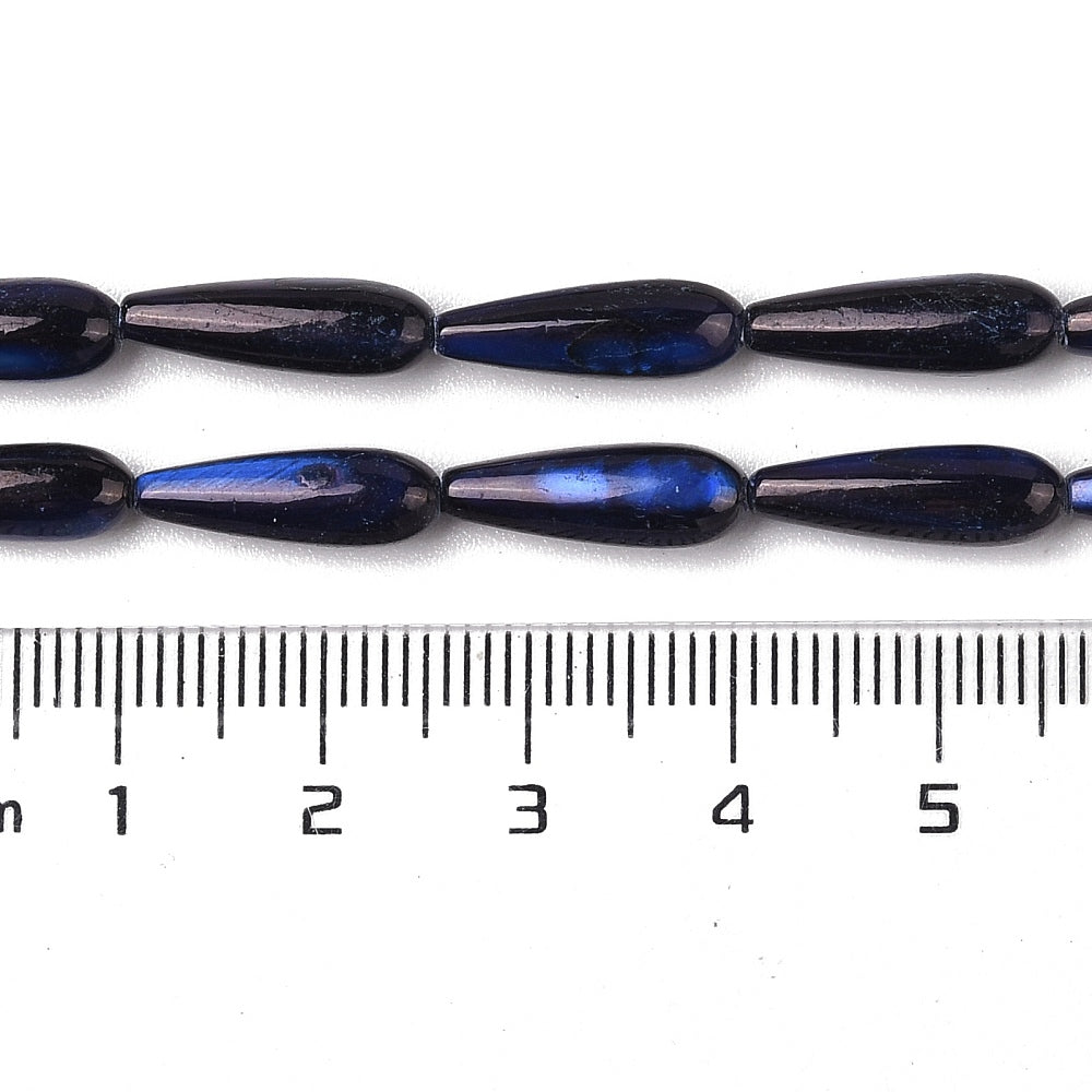 Midnight blue teardrop shell beads on strand, shown with ruler for size