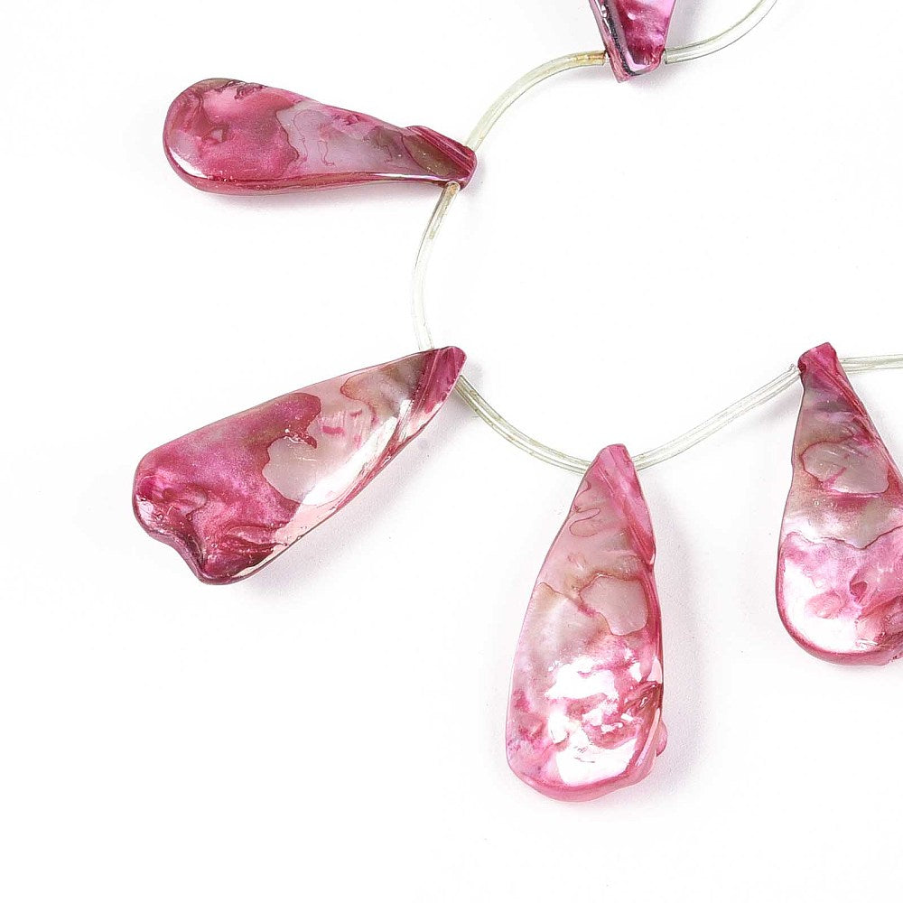 Cerise teardrop shell bead strand on wire, close-up view of translucent beads