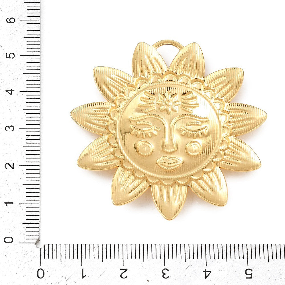 Sun charm pendant gold-tone shown with ruler for size, hanging loop