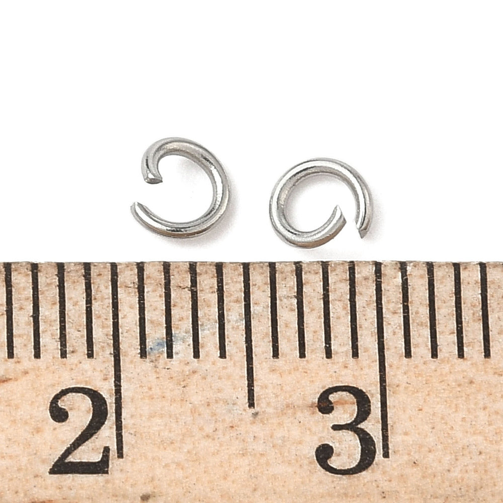 Small silver open jump rings next to ruler for size reference