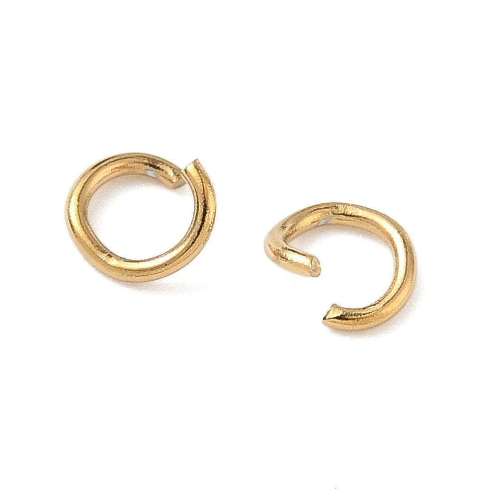 Gold-plated open jump rings, close-up of two circular rings with gap