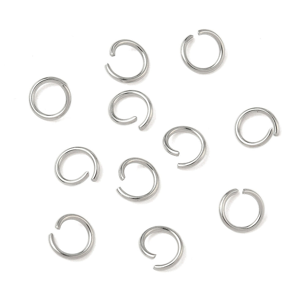 Stainless steel open jump rings in silver tone, scattered partially open loops