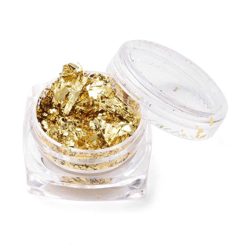 Gold metallic foil flakes in an open clear plastic storage jar
