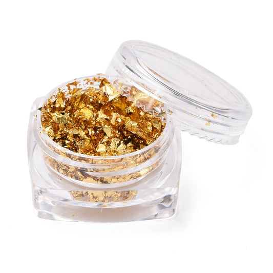 Golden metallic foil flakes in an open mini jar with clear lid