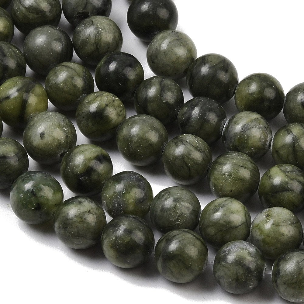 Close-up of olive green round jade beads with dark swirls and light speckling