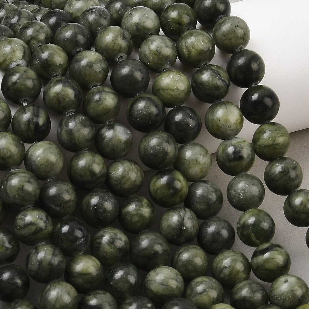 Olive green round jade beads strand, tight close-up of mottled green and dark beads