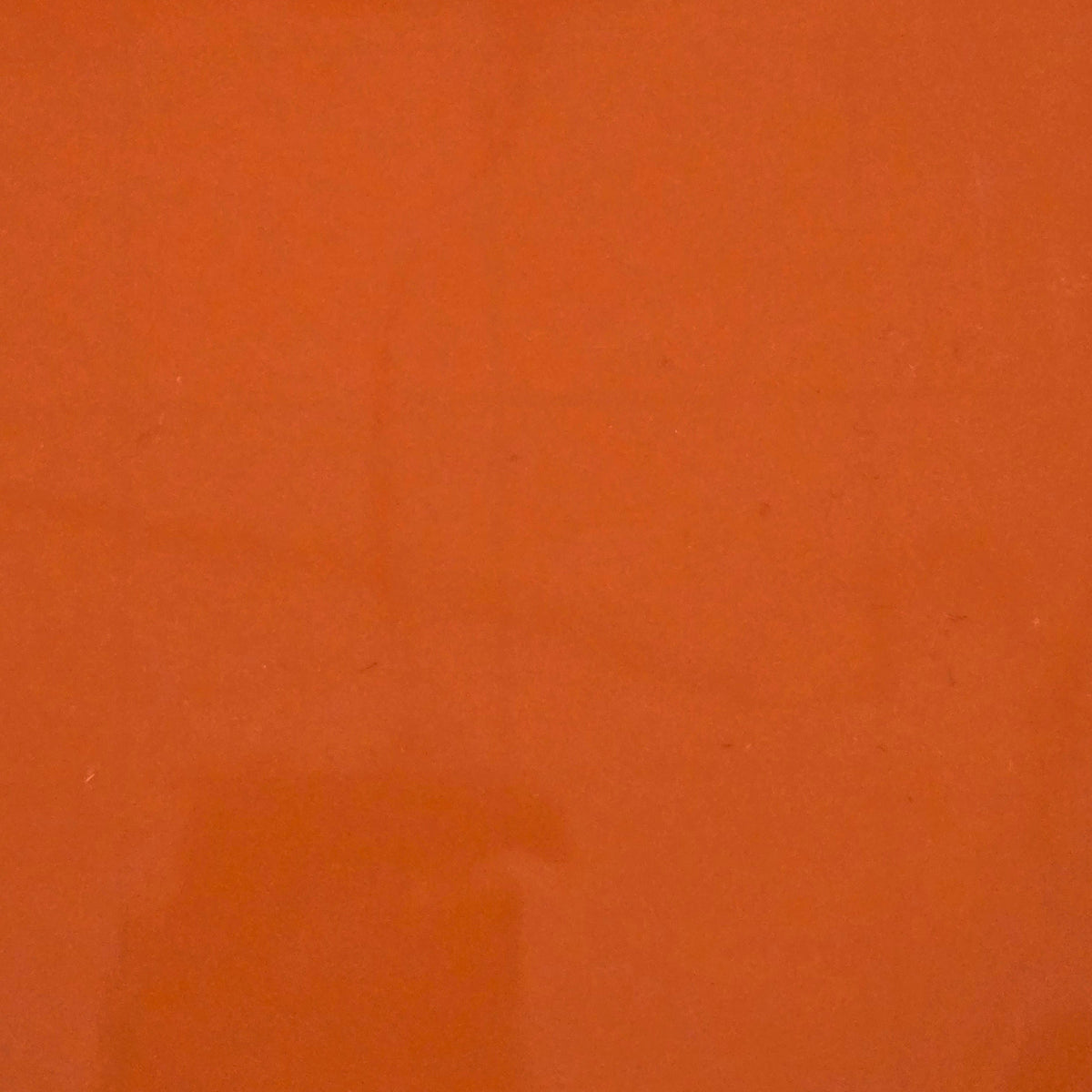 Glossy permanent vinyl sheet in dark orange, close-up surface