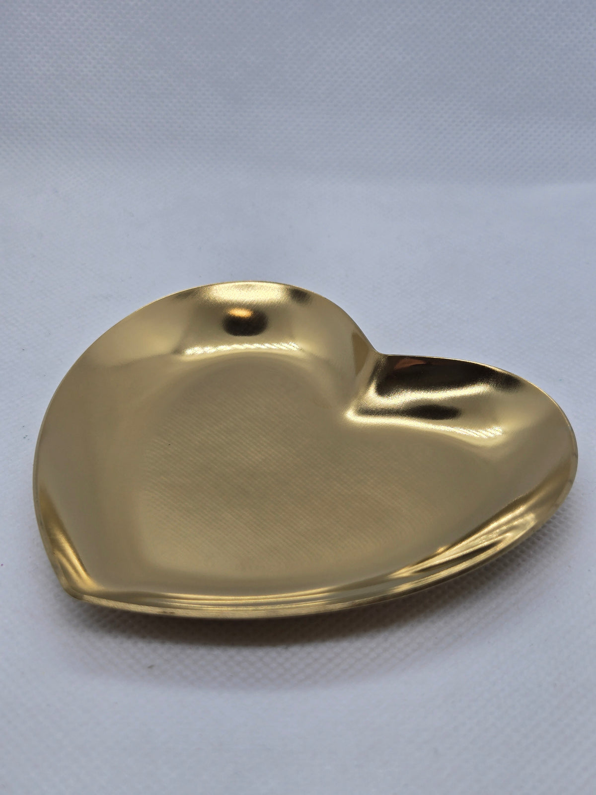 Gold heart-shaped plate with glossy reflective finish