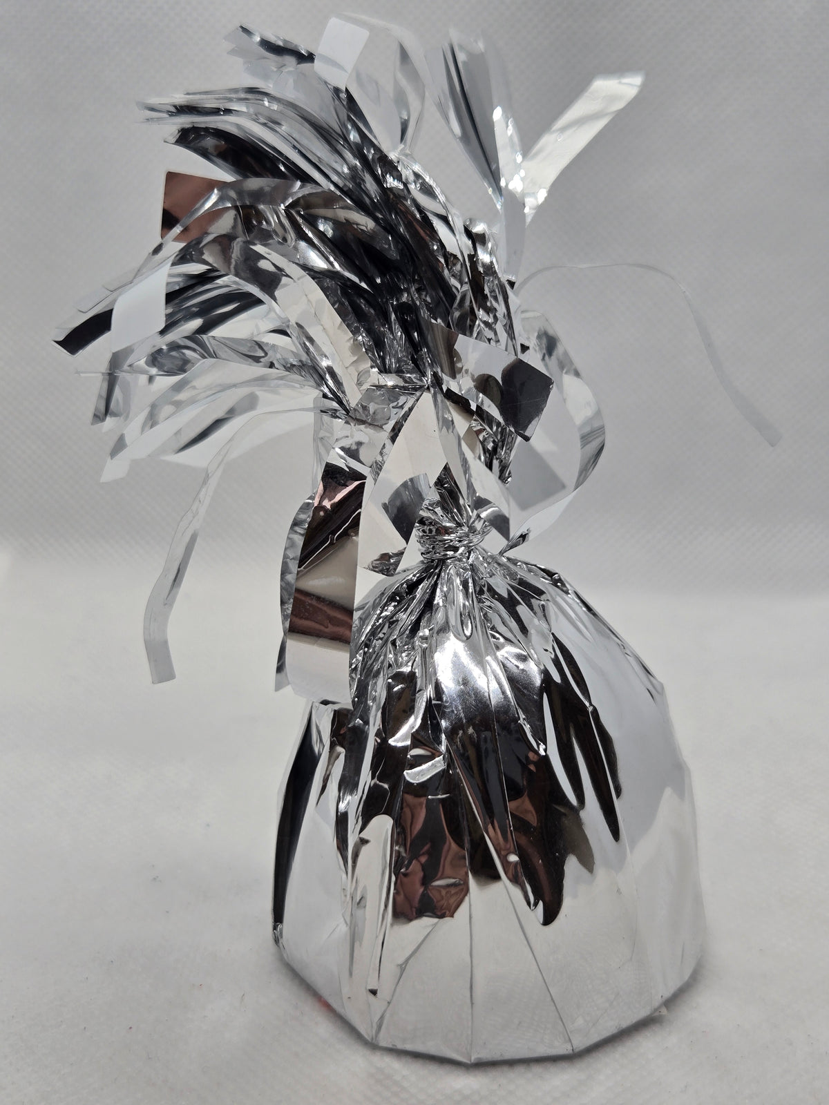 Silver foil balloon weight with crinkled ribbon top and tied string