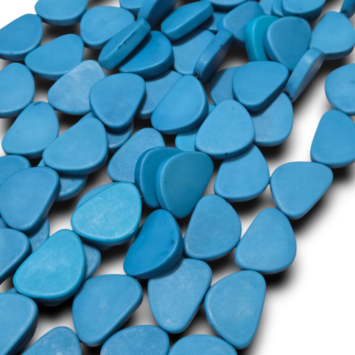 Light blue flat triangle resin beads strand, close-up of smooth matte beads